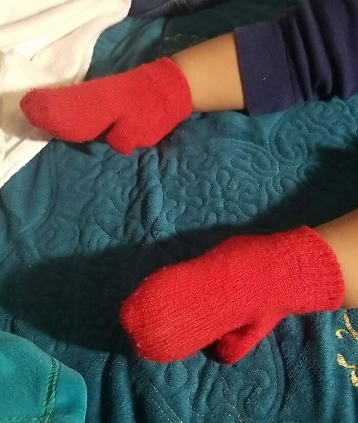 Manos de niño con guantes rojos, representando personas que probablemente llevan un día peor que el tuyo.