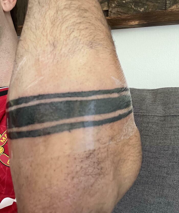 Tatuaje en brazo con dos líneas negras gruesas y delgadas, ejemplo de tatuajes que fueron una mala elección.