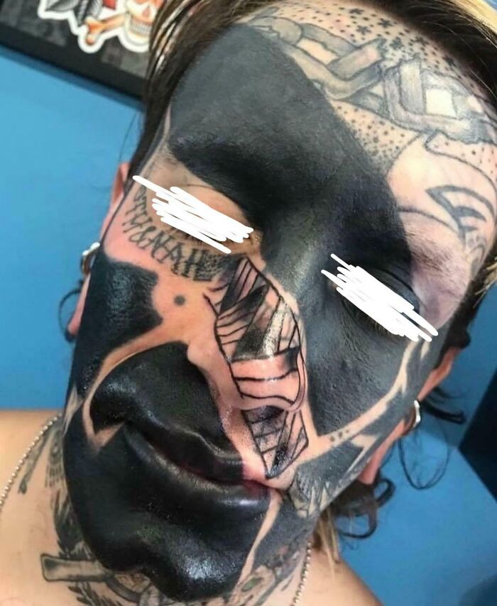 Tatuaje facial en negro intenso cubriendo gran parte del rostro, ejemplo de mala elección en tatuajes visibles.