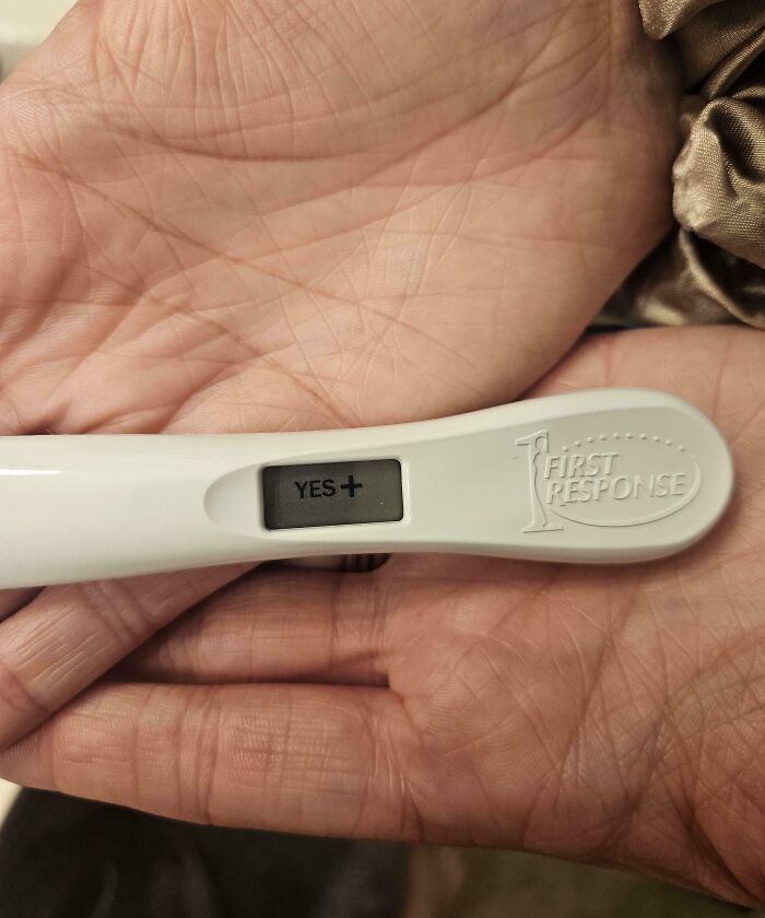 Prueba de embarazo positiva en manos, símbolo emotivo de momentos positivos y conmovedores para recobrar la fe en la humanidad.