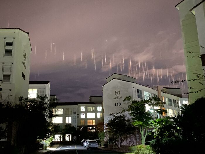 Edificios iluminados de noche con luces extrañas en el cielo, mostrando una de las coincidencias increíbles poco comunes.