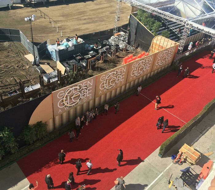 Vista aérea de alfombra roja en evento Golden Globe con personas caminando, foto curiosa que muestra otra perspectiva urbana.