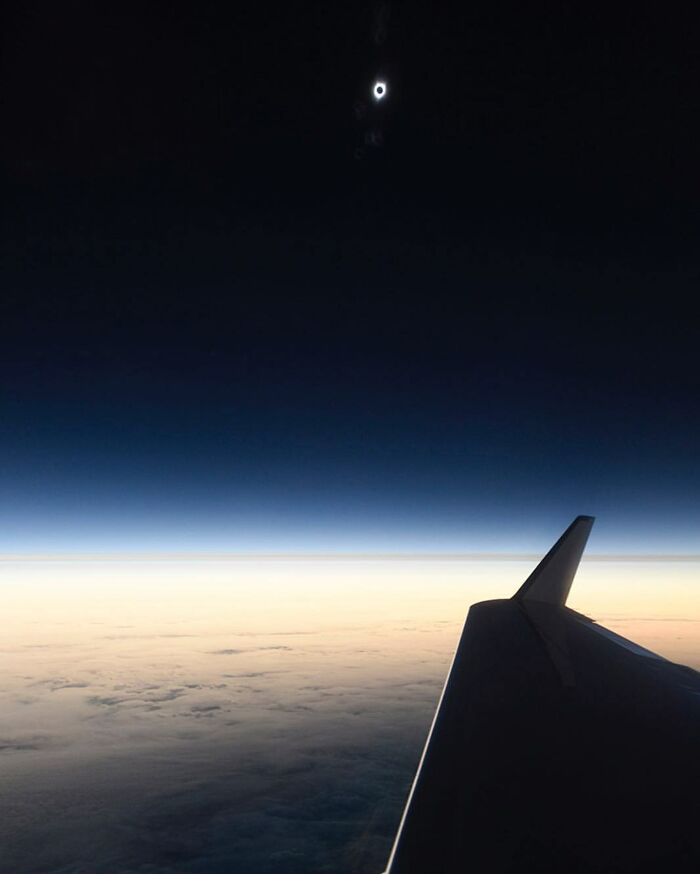 Vista desde un avión durante un eclipse solar total, una foto curiosa que muestra una perspectiva única del cielo y las nubes.