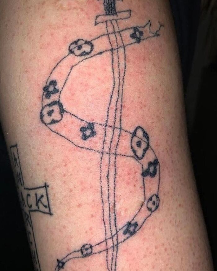Tatuaje mal realizado en brazo con líneas irregulares y figuras oscuras, ejemplo de personas que no ven lo horribles de sus tatuajes.