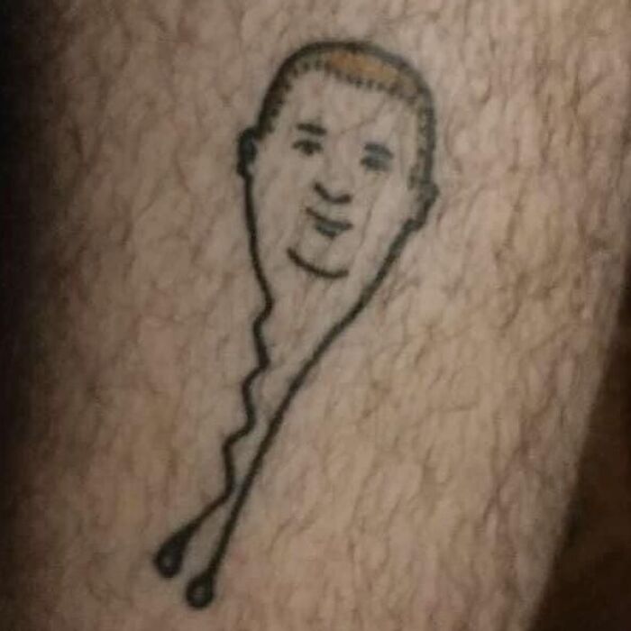 Tatuaje extraño en la piel mostrando un diseño de rostro poco claro entre personas con tatuajes horribles.