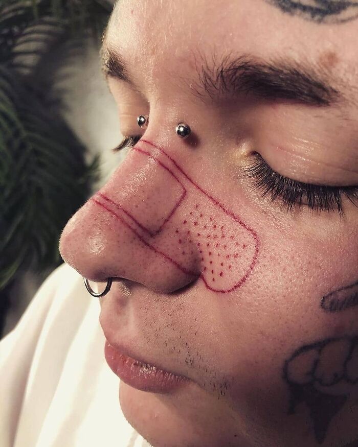 Persona con tatuaje de tirita en la nariz, mostrando un ejemplo de tatuajes horribles.