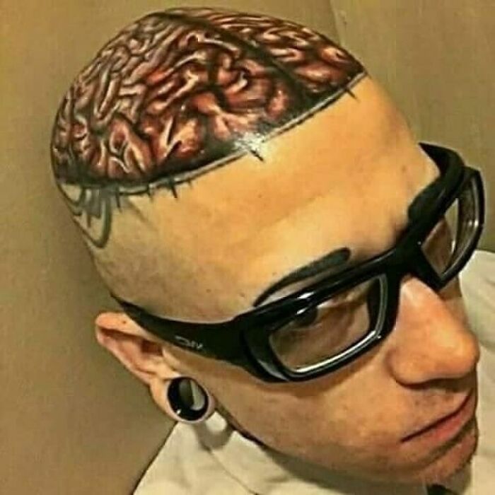 Hombre con tatuaje realista de cerebro en la cabeza, ejemplo de tatuajes que no se dan cuenta de lo horribles que son.