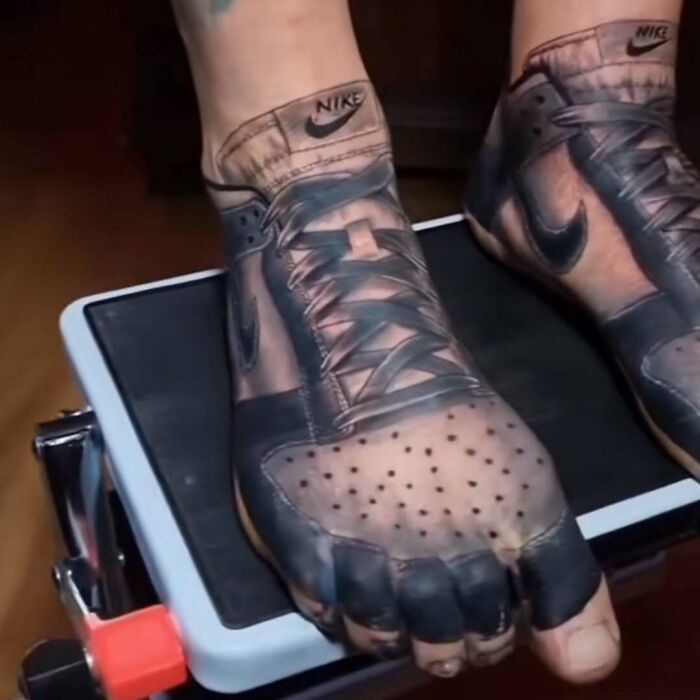 Tatuaje realista de zapatillas Nike en pies que muestra un diseño de tatuajes horribles y poco convencionales.