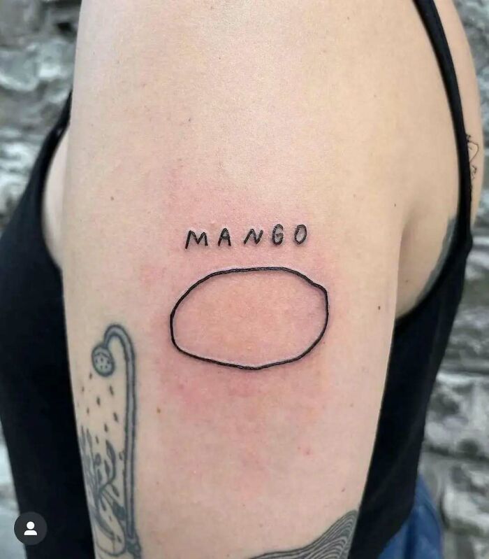 Tatuaje extraño de un mango en un brazo, mostrando una forma simple y líneas finas.