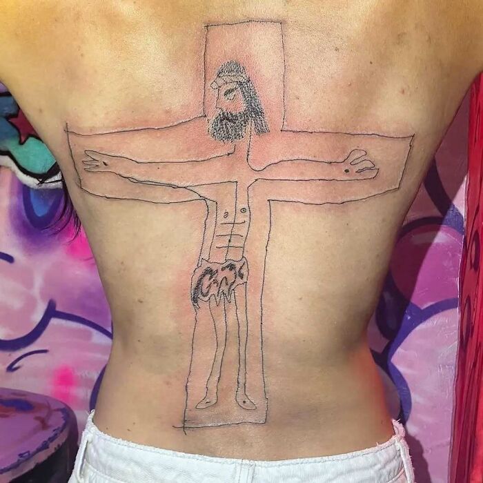 Persona con tatuaje incompleto en la espalda, mostrando un estilo poco profesional en un entorno colorido.