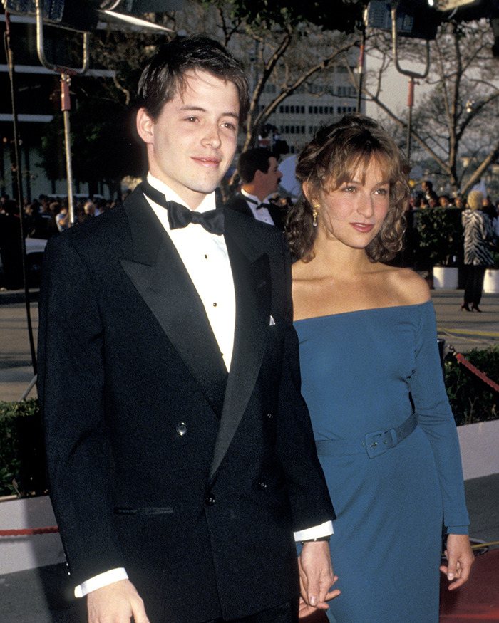 Pareja de celebridades en un evento formal al aire libre, representando escándalos olvidados.