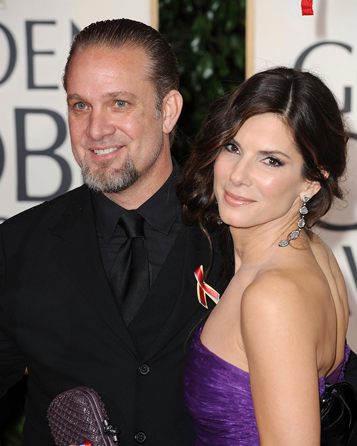 Pareja de celebridades en evento de alfombra roja, vestidos de gala y sonriendo.