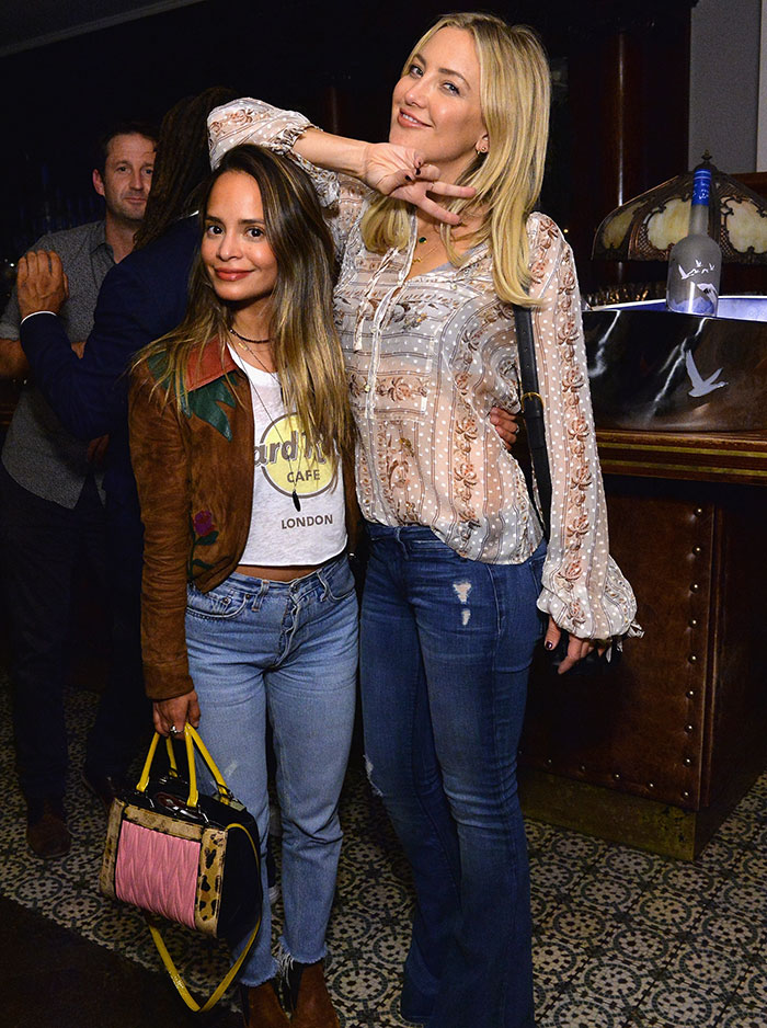 Dos mujeres posando juntas en un evento, con detalles poco glamurosos fuera de la alfombra roja.