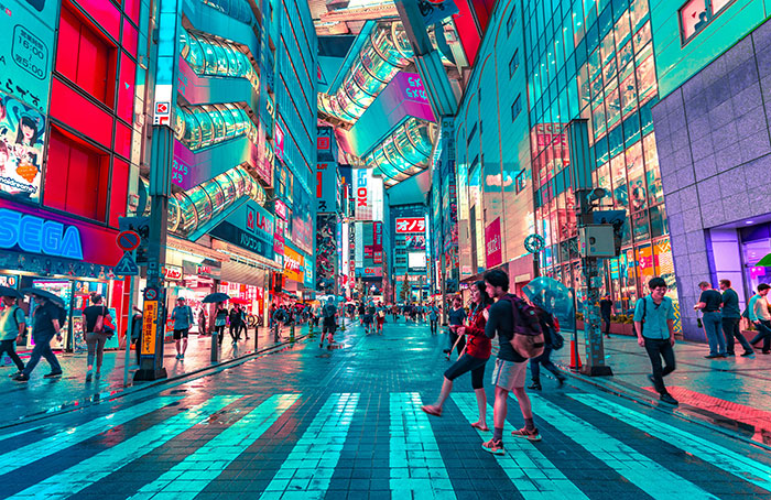 Personas cruzan una calle iluminada por luces de neón en una ciudad futurista, un ejemplo de choque cultural urbano.