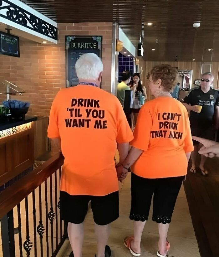Pareja mayor con camisetas divertidas en naranja, ejemplo de camisetas ridículas que quizá no habría que ponerse en público.