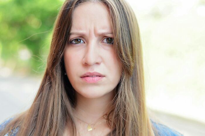 Mujer joven con expresión de preocupación y tristeza, reflejando momentos de darse cuenta de no casarse con su pareja.