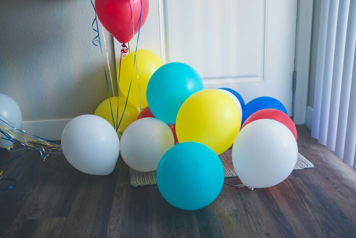 Globos de colores en suelo de madera, ejemplo de objetos aparentemente inofensivos con mucho peligro en el hogar.