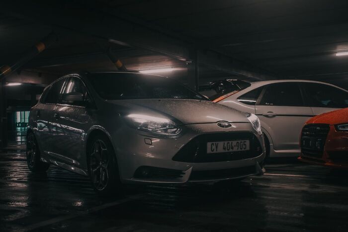 Coche gris estacionado en un garaje oscuro representando ese momento de saber que había que irse ya mismo.