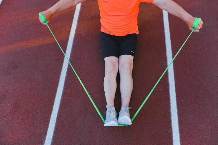 Persona usando cuerda para saltar actividad aparentemente inofensiva con peligro oculto en zona deportiva exterior.