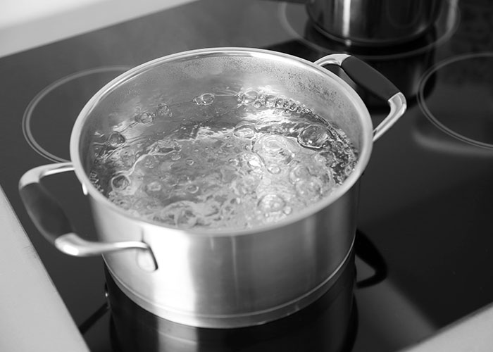 Olla de agua hirviendo en una estufa, simboliza las consecuencias de ignorar un 