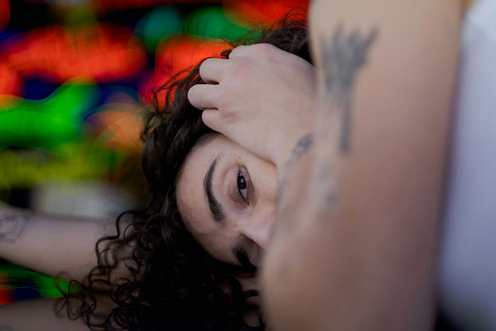 Persona con tatuajes abrazando el rostro, representando acción por si acaso y prevención de tragedias.