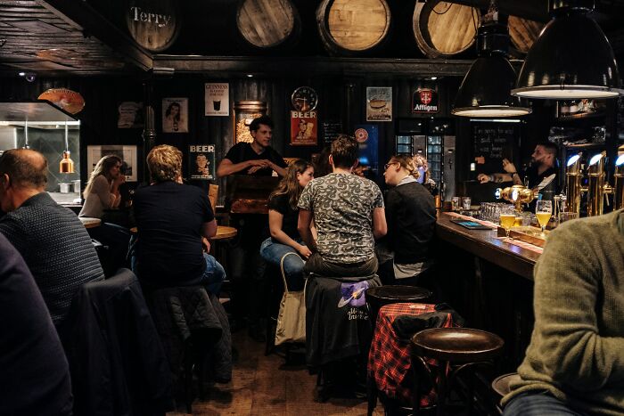 Personas en bar oscura compartiendo momentos en que supieron que tenían que irse ya mismo en reunión social.
