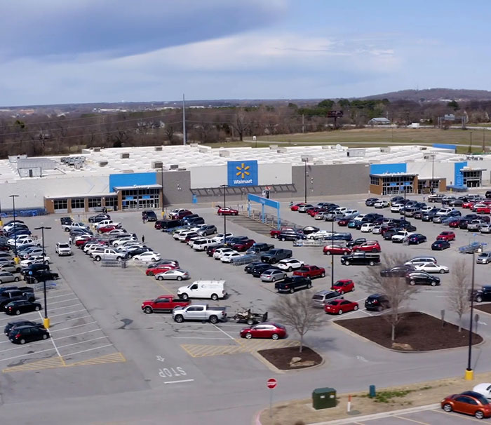 Walmart parking lot filled with cars, showcasing a busy retail environment on a clear day.