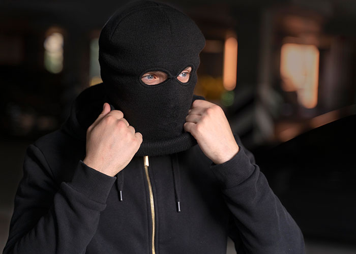 Persona con pasamontañas negro en situación que parece peligrosa, ilustrando experiencias salvajes.
