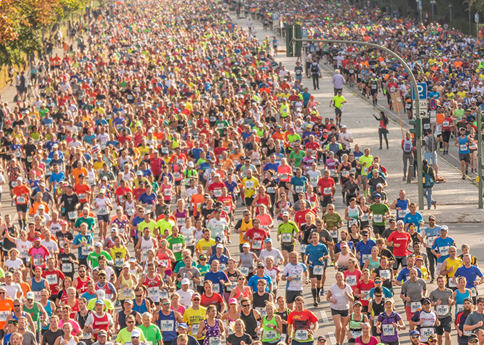 Gran multitud corriendo en una carrera urbana, símbolo de experiencias salvajes y momentos inolvidables.