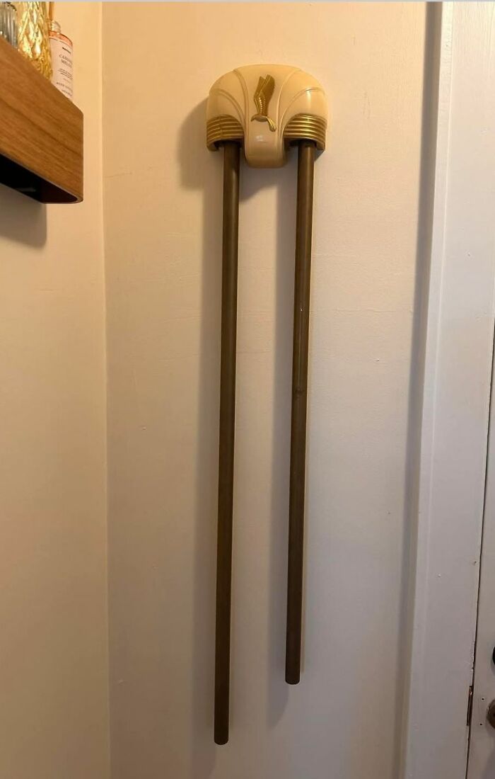 Descubrimiento curioso en casas olvidadas: accesorio vintage para colgar toallas con diseño retro en pared beige.