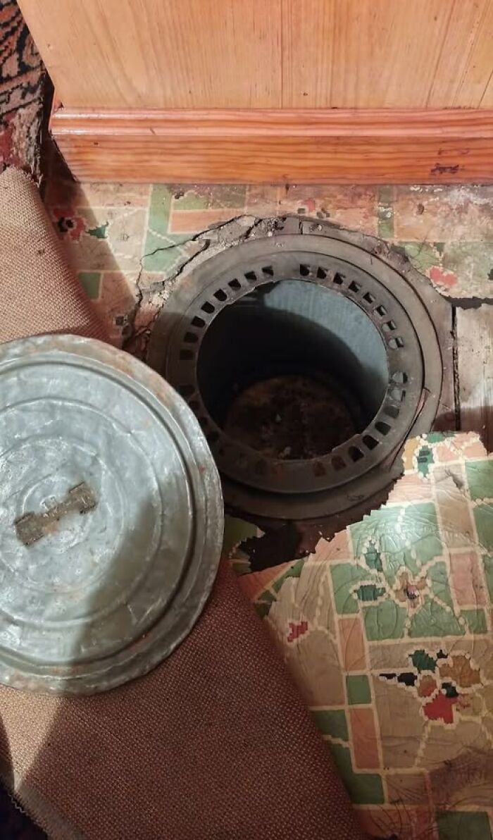 Tapa metálica descubierta en pisos antiguos con patrones desgastados en una casa abandonada curiosa.