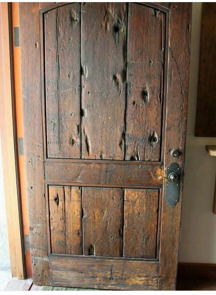 Puerta antigua de madera con marcas y desgaste visible en casas abandonadas, descubrimientos curiosos en hogares olvidados.