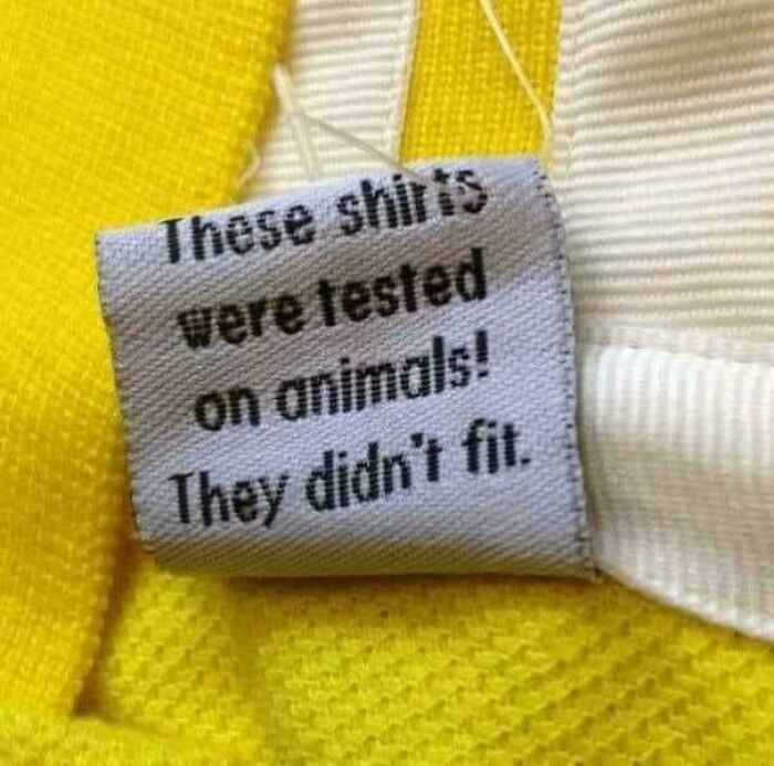 Etiqueta en camiseta amarilla con texto humorístico, imagen bendecida y maldita mostrando contraste irónico y divertido.