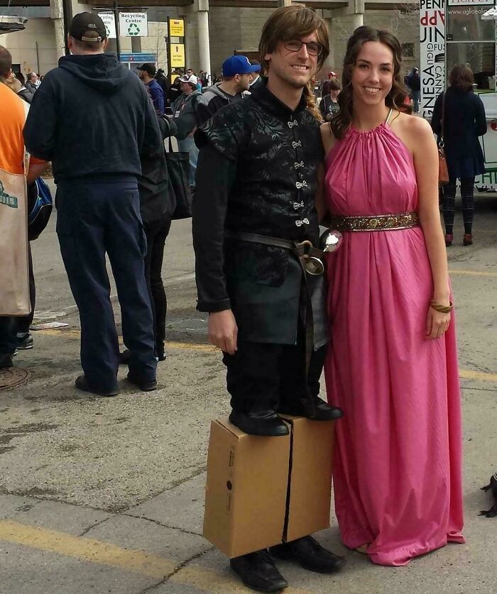 Pareja disfrazada creativamente con juego visual en evento, imagen bendecida y maldita al mismo tiempo en la calle.