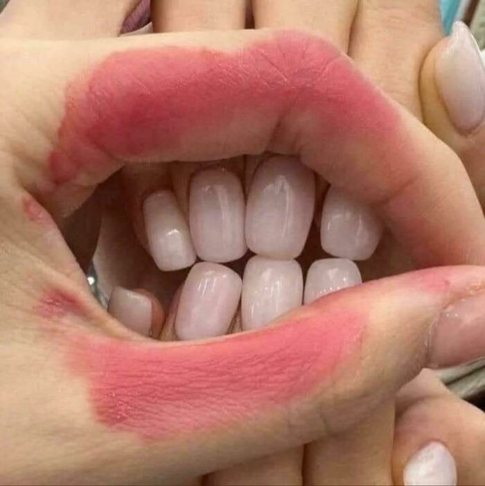 Manos con marcas rojas formando una boca con uñas blancas, imagen bendecida y maldita al mismo tiempo con efecto visual curioso.