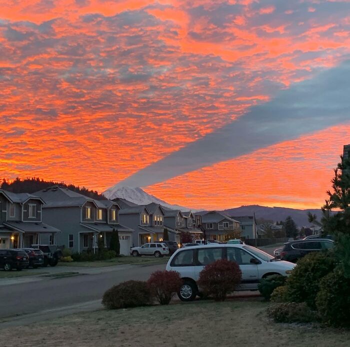 Atardecer con nubes y sombra gigante sobre montaña nevada en un vecindario silencioso, coincidencia increíble natural.
