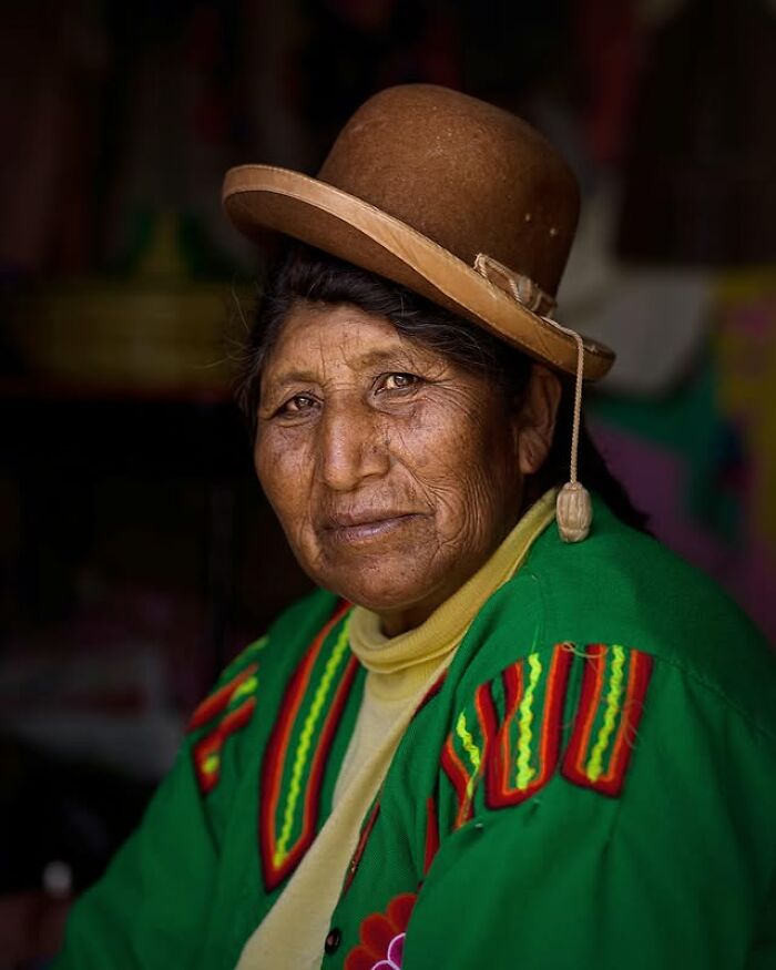 Retrato elocuente de mujer mayor con sombrero tradicional y ropa colorida, mostrando la diversidad cultural mundial.