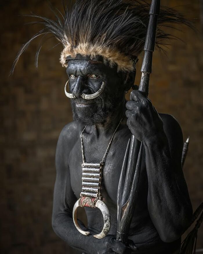 Retrato elocuente de persona mayor con pintura corporal negra y adornos tradicionales en el mundo, fotografía de Massimo Bietti.