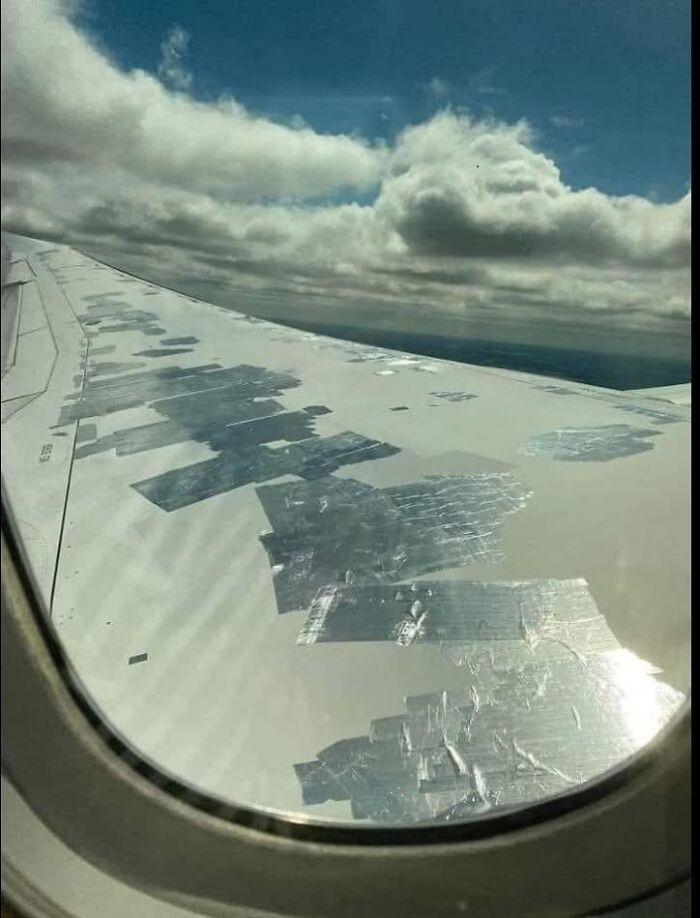 Vista desde ventana de avión con ala parchada con cinta adhesiva, mostrando cosas que salieron mal en reparación improvisada.