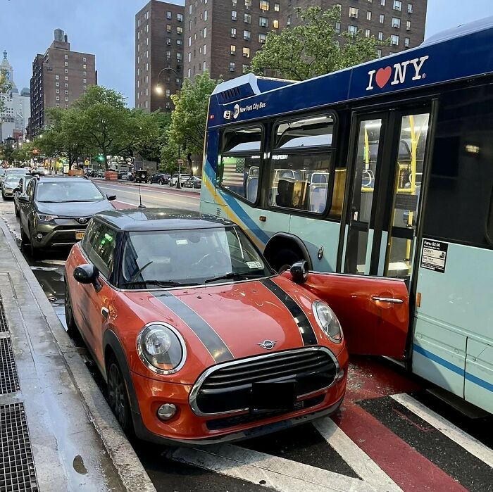 Coche rojo con puerta abierta bloqueando un autobús en la ciudad, mostrando una de las cosas que salieron mal y la gente compartió.