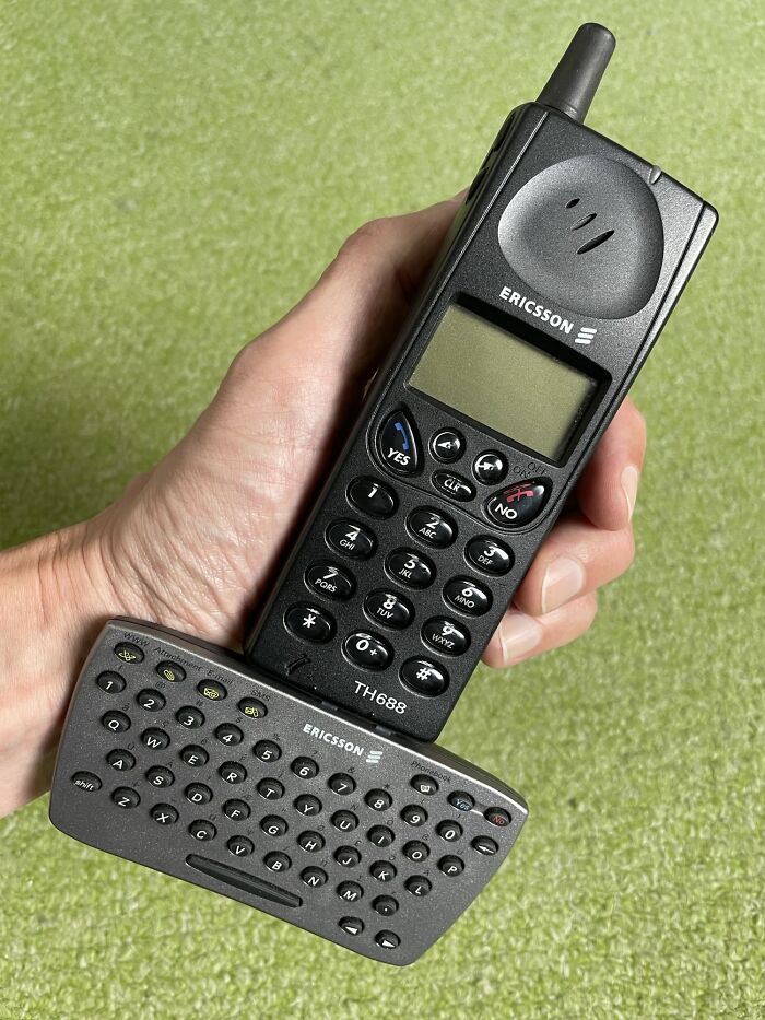 Teléfono móvil Ericsson antiguo con teclado completo mostrado en comparaciones increíbles de perspectiva temporal.