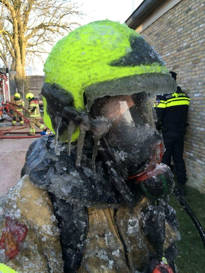 Bombero congelado con equipo de protección completa durante una intervención en un ambiente helado, foto impactante.