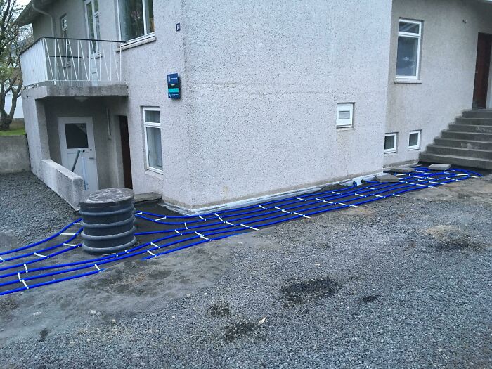 Tuberías azules instaladas alrededor de una casa en tierra, detalle interesante para fotos tan interesantes.