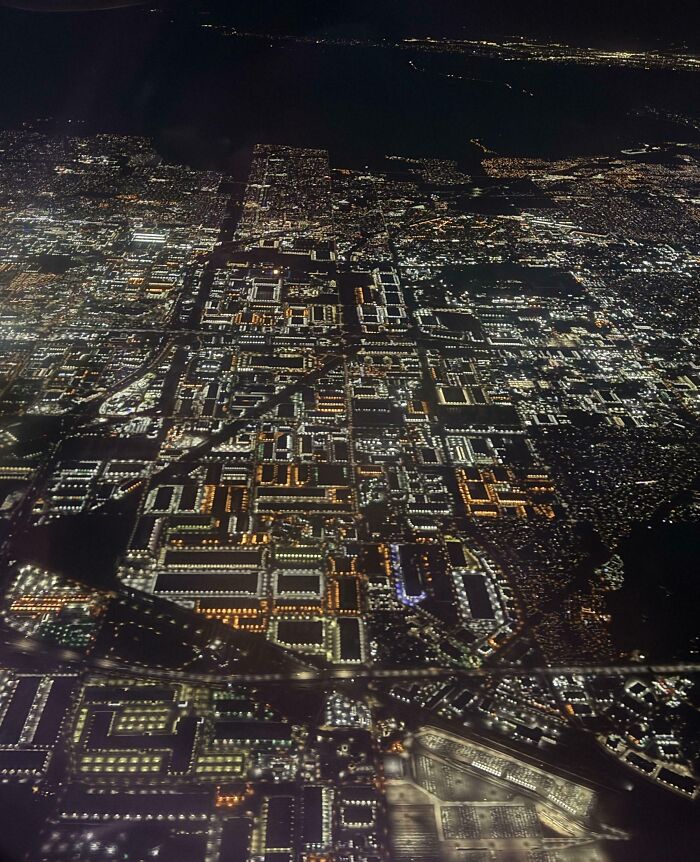 Vista aérea nocturna de una ciudad iluminada con luces brillantes en una foto interesante para SEO.