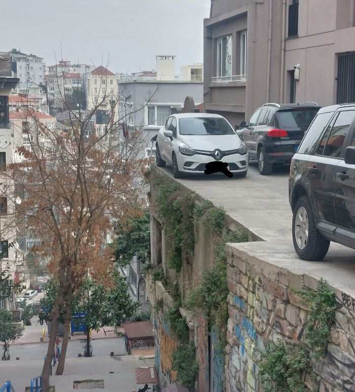 Coches estacionados al borde de un acantilado urbano en una imagen de fotos interesantes y sorprendentes.