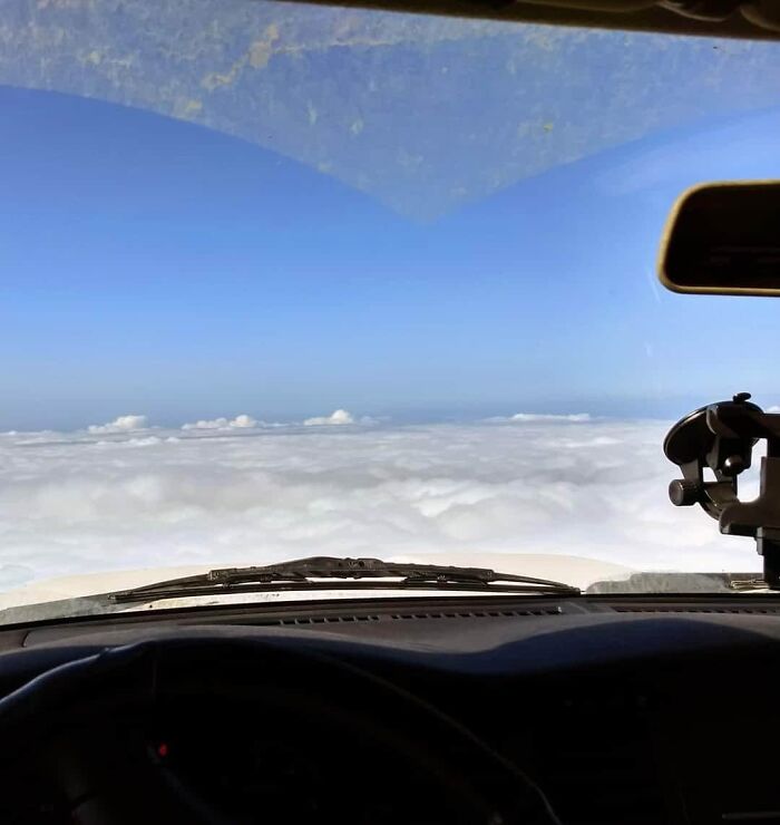 Vista desde el interior de un vehículo mostrando nubes que parecen un mar, objetos interesantes que parecen otras cosas.