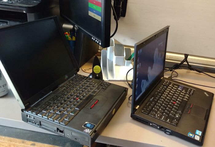 Comparación temporal con laptops antiguas y modernas sobre un escritorio mostrando evolución tecnológica notable.