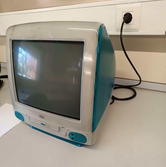 Computadora iMac antigua en escritorio mostrando comparación tecnológica con nueva perspectiva temporal.