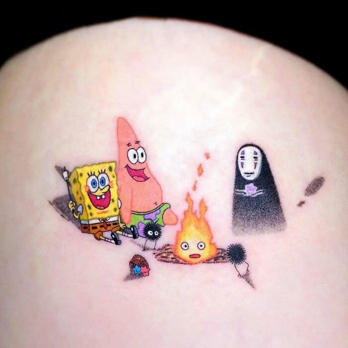 Tatuajes coloridos y creativos con personajes de caricaturas haciendo una fogata, ejemplo de tatuajes graciosos y originales.
