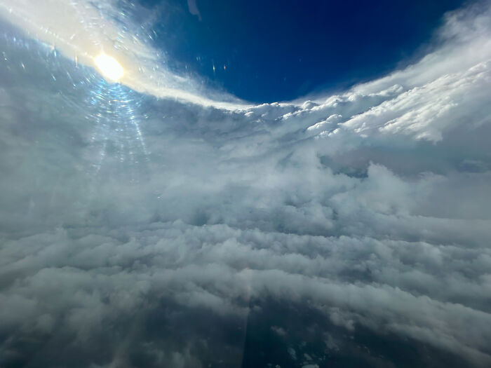 Vista aérea de nubes densas bajo un cielo azul brillante, una foto interesante que parece ilegal sin protección visual.